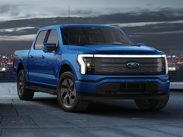 A blue 2024 Ford F-150 Lightning driving down the highway