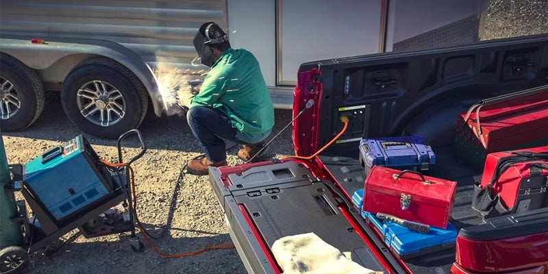 A man working using the power outlet on his Ford F-150