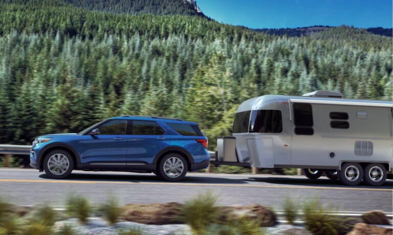 Blue 2021 Ford Explorer towing a trailer