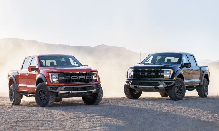 Two 2023 Ford F-150s parked in desert