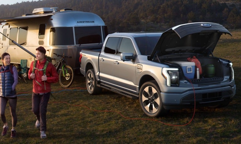 2023 Ford F-150 Lightning parked at a campsite with trailer