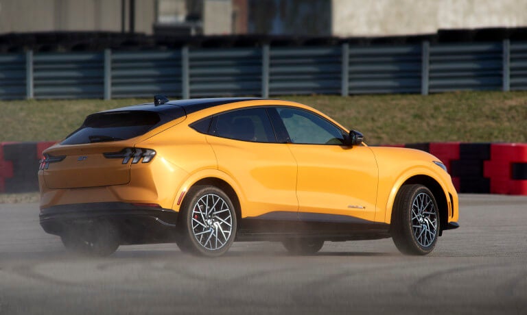 2025 Ford Mustang Mach-E driving on dusty racetrack