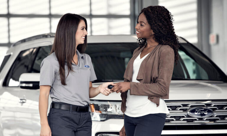Ford employee handing off keys to woman
