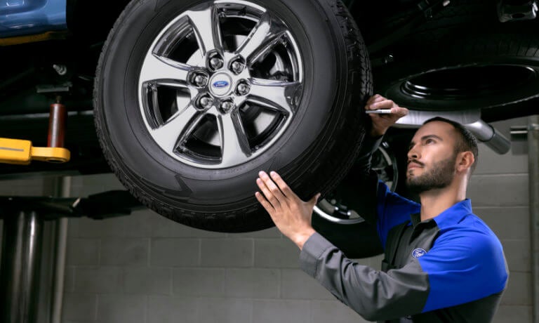 Ford technician checking tire