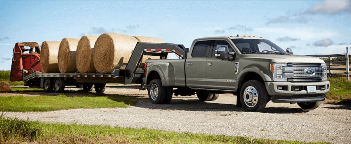 A 2019 Ford Super Duty towing a trailer full of hay