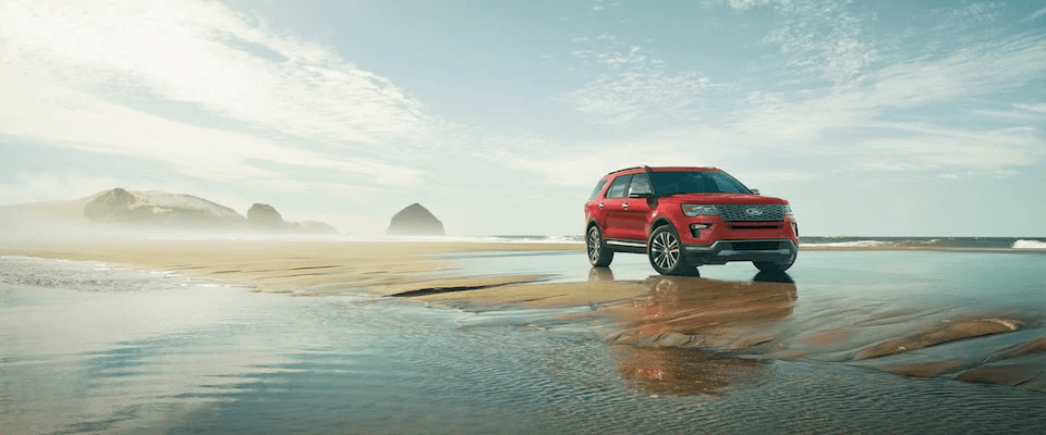 A red 2019 Ford Explorer parked on a beach