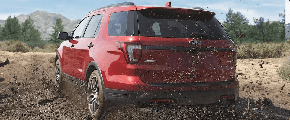 A red 2019 Ford Explorer driving through the mud