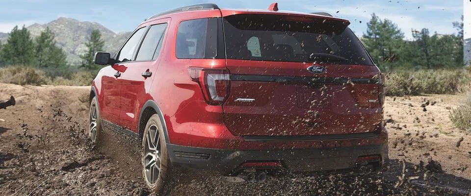 A red 2018 Ford Explorer driving through the mud