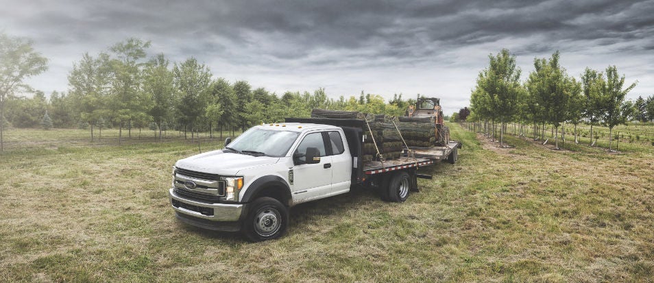 A 2019 Ford Super Duty truck towing heavy equipment